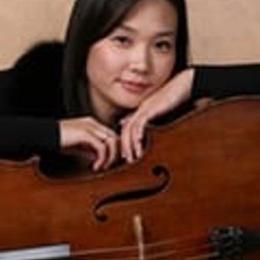 深色头发的女士在大提琴上戴着深色的上臂